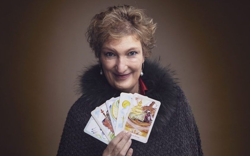 Susanne Taylor holder en vifte af tarotkort. Tarotcoach til firma events og teambuilding. Billede beskåret i 8:5